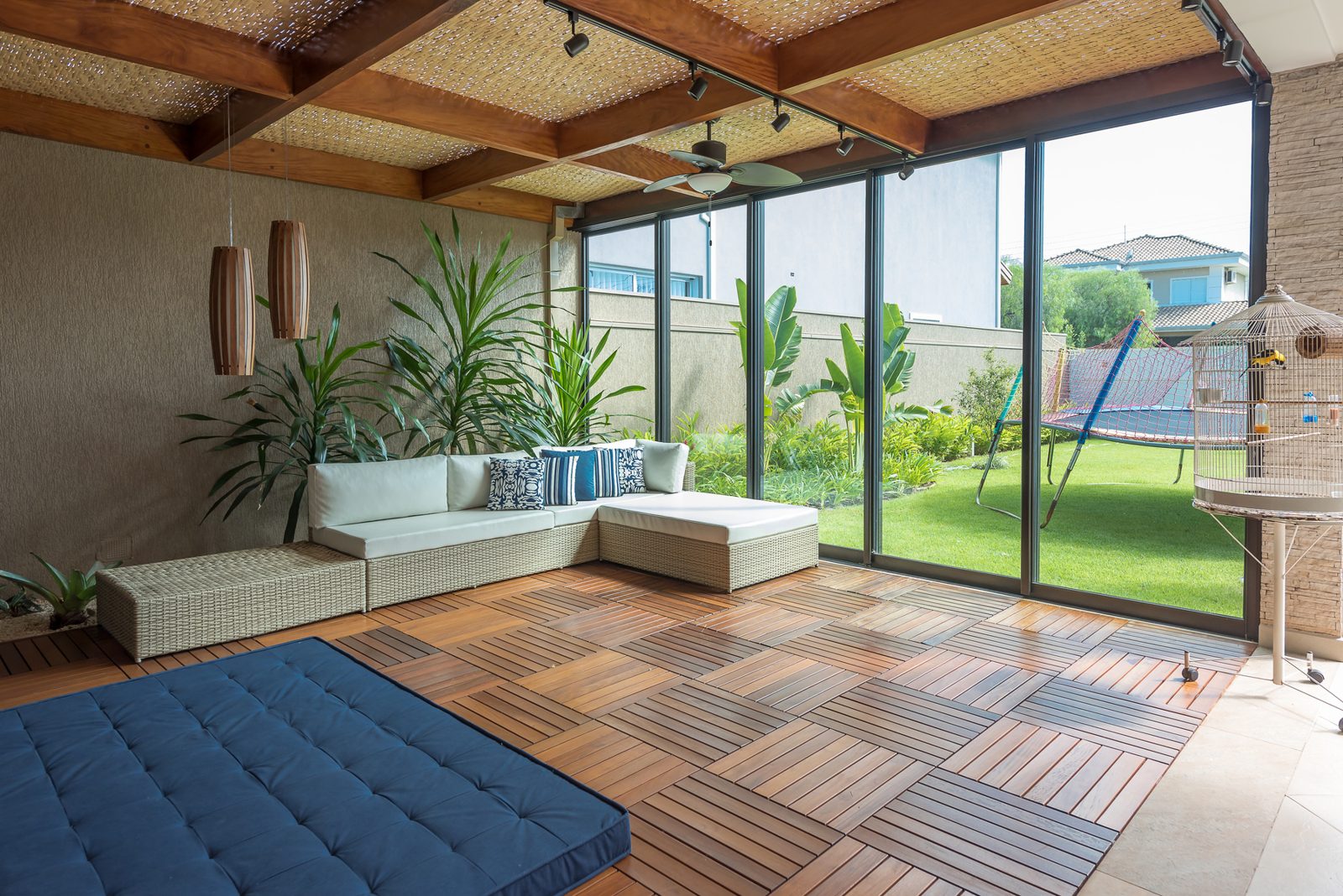 Salón abierto al jardín con piso de madera tropical · Catálogo Madeira Tech 2026, derechos por validar